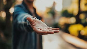 Person extending an open hand forward.